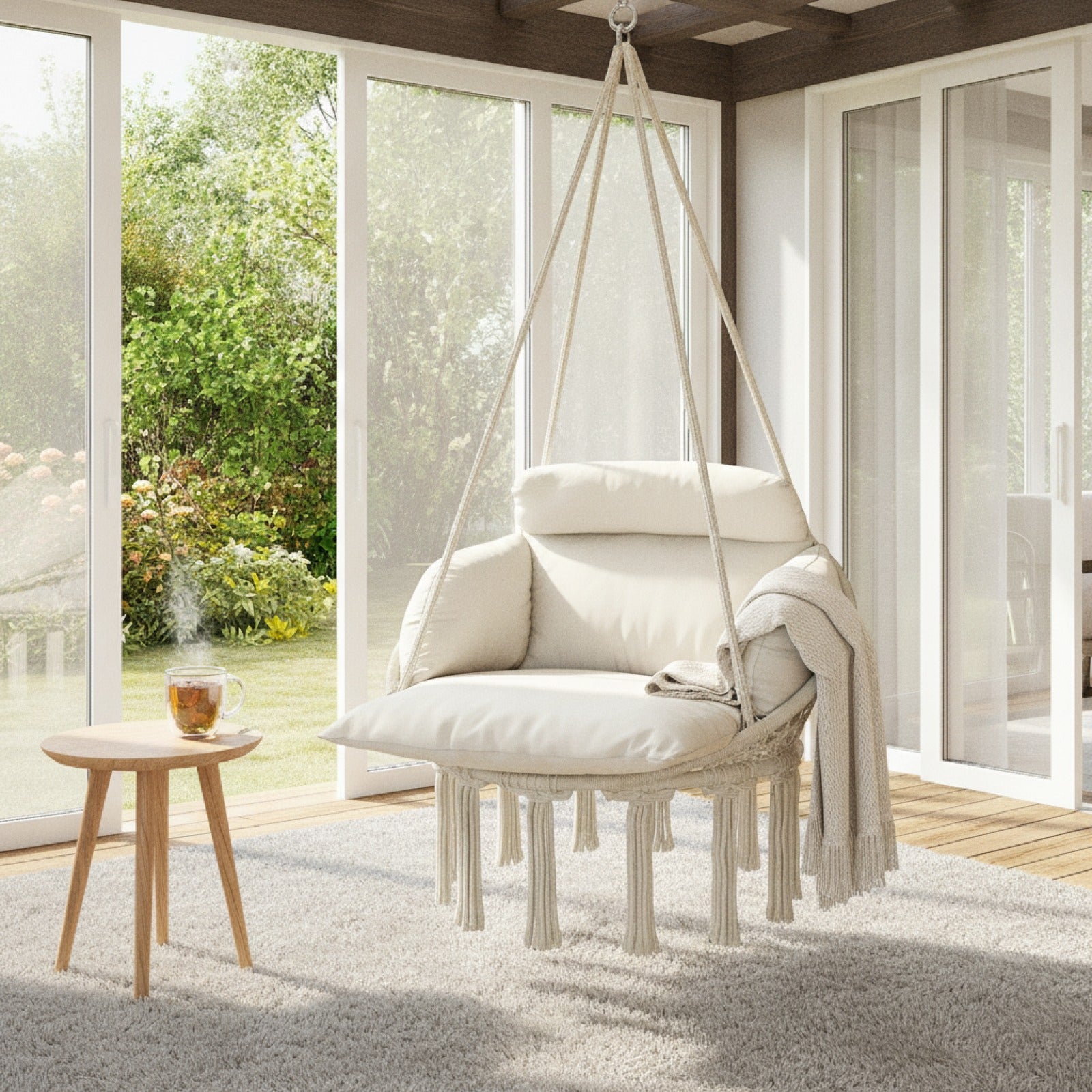 Hamac chaise suspendu NELIA près d’une baie vitrée dans un intérieur moderne et lumineux